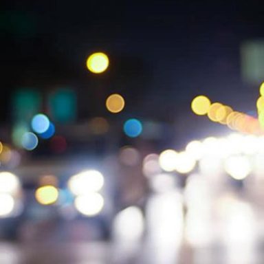 Blurred city lights at night creating a bokeh effect with colorful orbs.